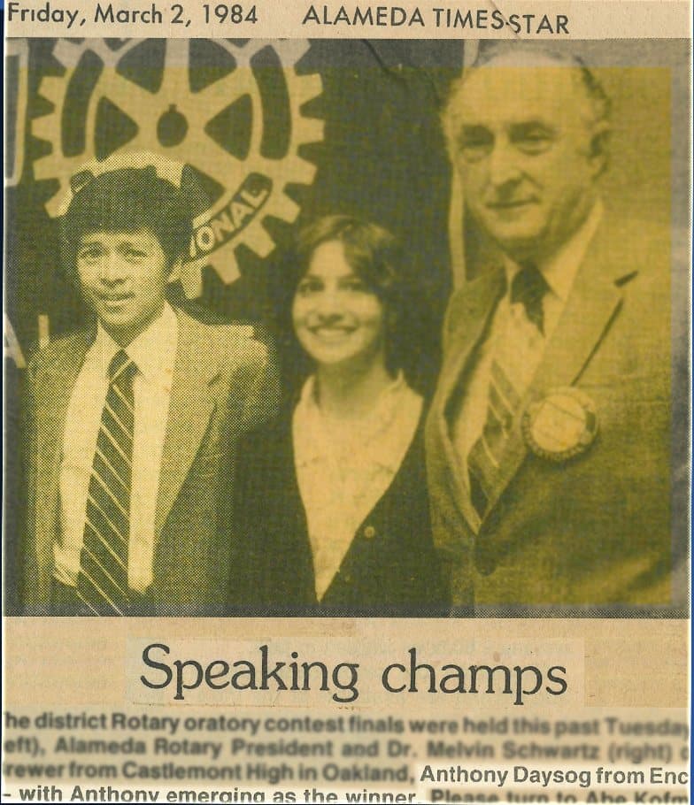 Alameda Times-Star clipping from Friday, March 2, 1984, headlined “Speaking champs”: Anthony Daysog of Encinal High, in a suit and tie, stands with another finalist and Alameda Rotary President Dr. Melvin Schwartz after the district Rotary oratory contest finals, which he won.