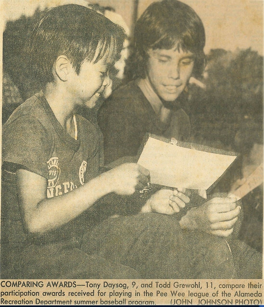 Newspaper photo captioned “Comparing Awards”: Tony Daysog, 9, and Todd Grewohl, 11, compare the participation awards they received for playing in the Pee Wee league of the Alameda Recreation Department summer baseball program.